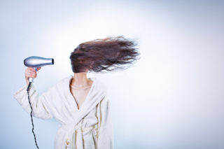Mulher secando o mega hair com secador